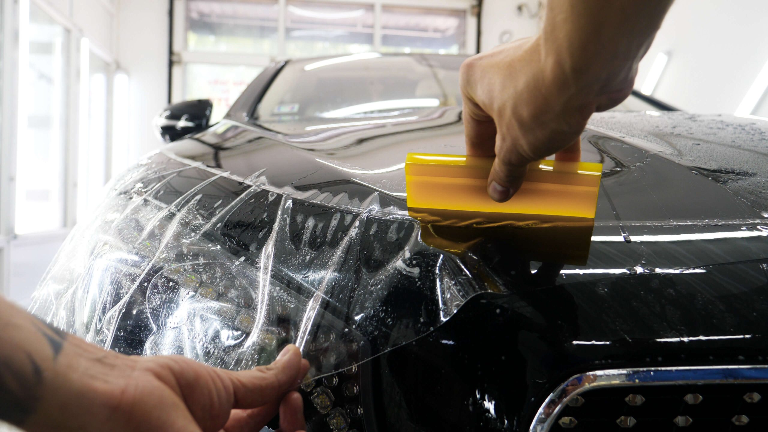 Paint Protection Film being applied to the hood of a car
